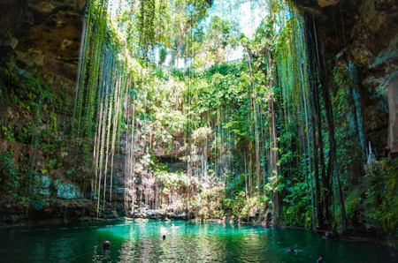 Cenote du Yucatán : eau turquoise sous voûte rocheuse, passerelles en bois